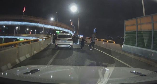 男子立交桥上跳车后拦车，女伴跪地抱腿央求，警方回应